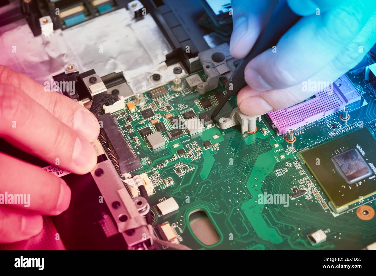 L'homme répare l'ordinateur. Un technicien de maintenance pour réparer un ordinateur portable, chez White Desk Banque D'Images