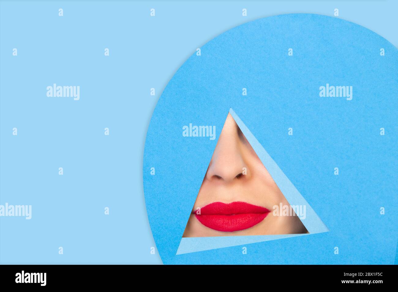 Calme. Gros plan femelle rouge lèvres peeks à travers le triangle dans fond bleu. Style géométrique tendance, espace de copie. Couleurs éclatantes. Émotion cachée, maquillage. Vente, proposition, finance et concept commercial. Banque D'Images