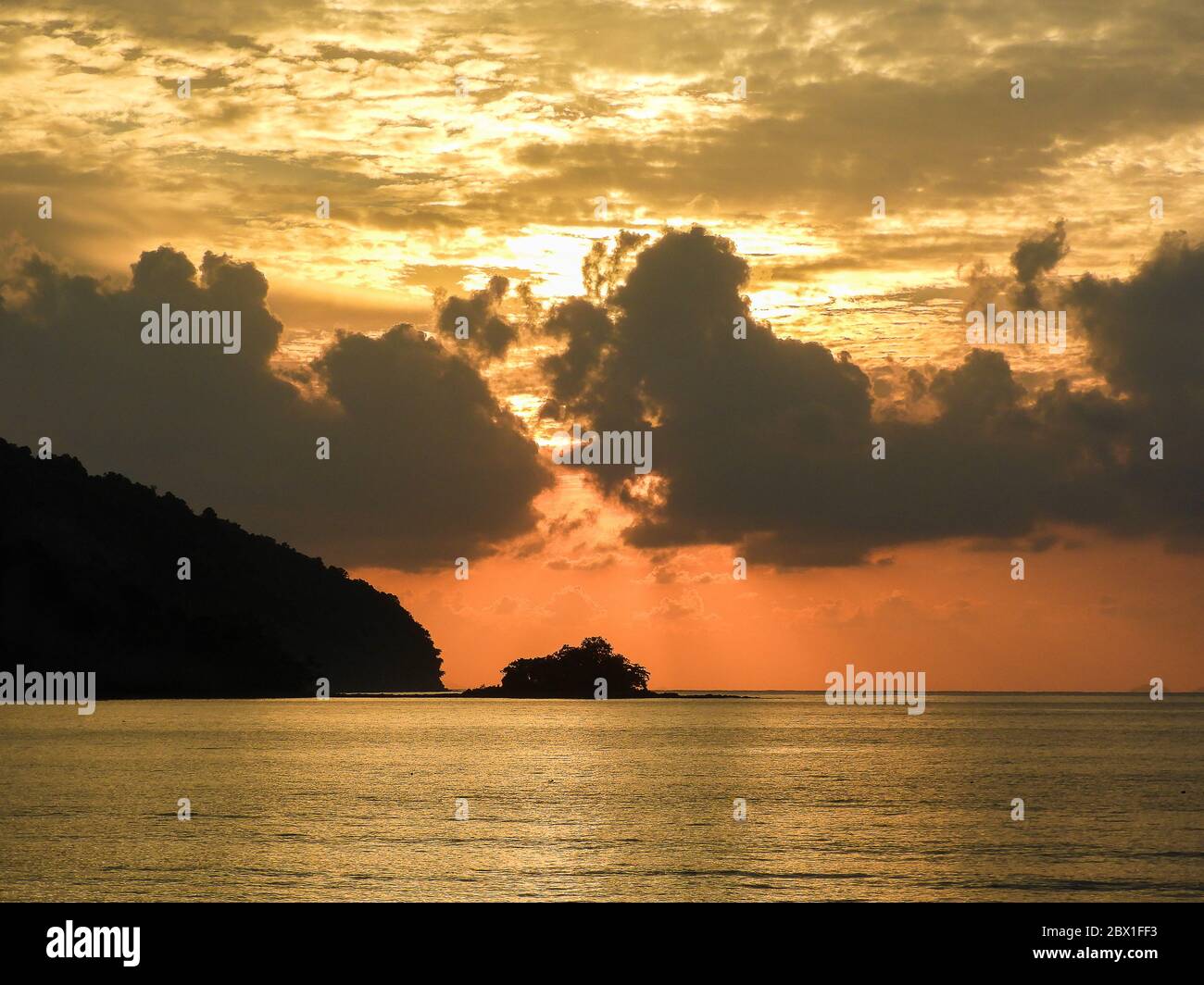 Datai Bay, Langkawi, Malaisie. Coucher de soleil orange spectaculaire sur les eaux tranquilles de la mer d'Andaman. Banque D'Images