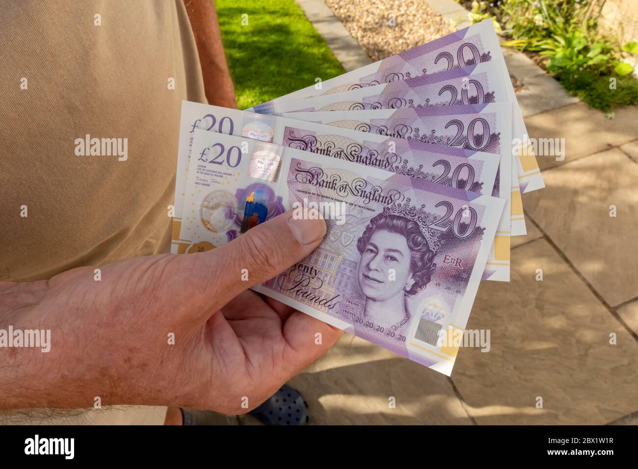Gros plan de l'homme qui détient £20 billets de vingt livres billets  billets argent liquide coût de la vie concept Angleterre Royaume-Uni  Grande-Bretagne Photo Stock - Alamy