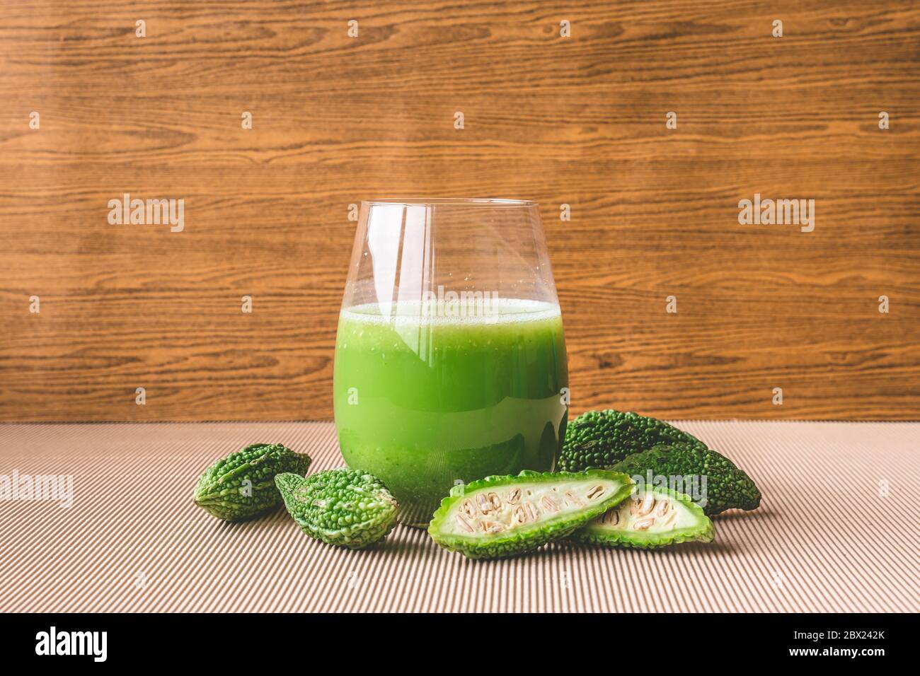 Jus de plantes avec melon amer ou gourde amer sur fond de bois. Banque D'Images