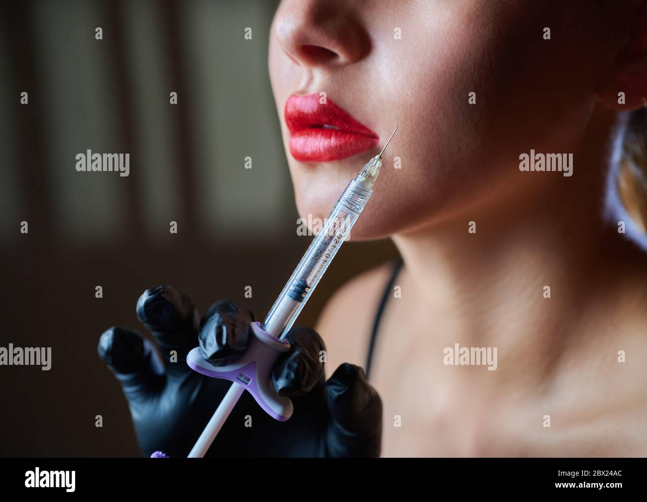 Cosmétologie. Portrait de la belle jeune femme visage avec seringue. Soins de beauté. Injections cosmétiques ou botox Banque D'Images