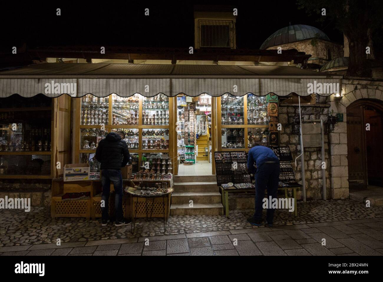 SARAJEVO, BOSNIE - 15 AVRIL 2017 : boutique de souvenirs dans le quartier Bascarsija de Sarajevo la nuit, avec des métiers typiques de cuivre métallique. Bascars Banque D'Images