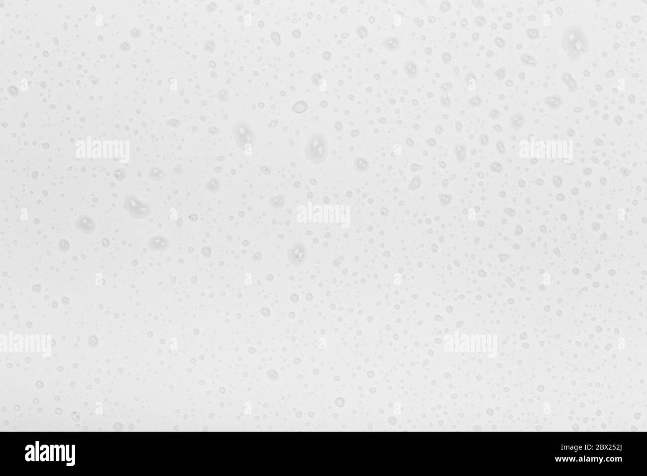 De l'eau s'est goutte sur fond de verre. Gouttes de pluie sur fond de verre blanc Banque D'Images