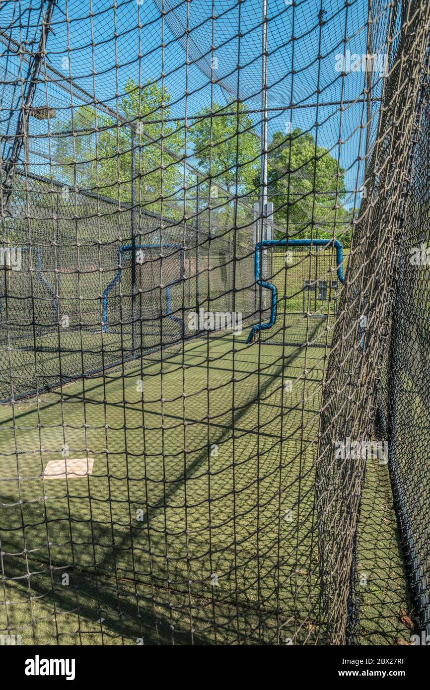 Des cages de base-ball vides et vides dans un terrain de baseball d'un parc ont été fermées en raison de la pandémie Covid-19 au début du printemps Banque D'Images