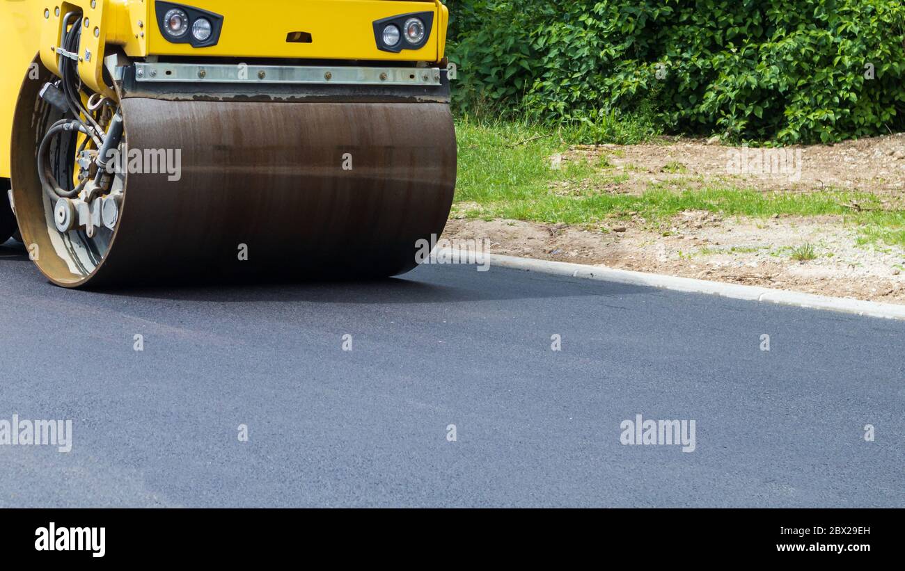Asphalte noir frais sur la nouvelle route. La construction en cours. Banque D'Images
