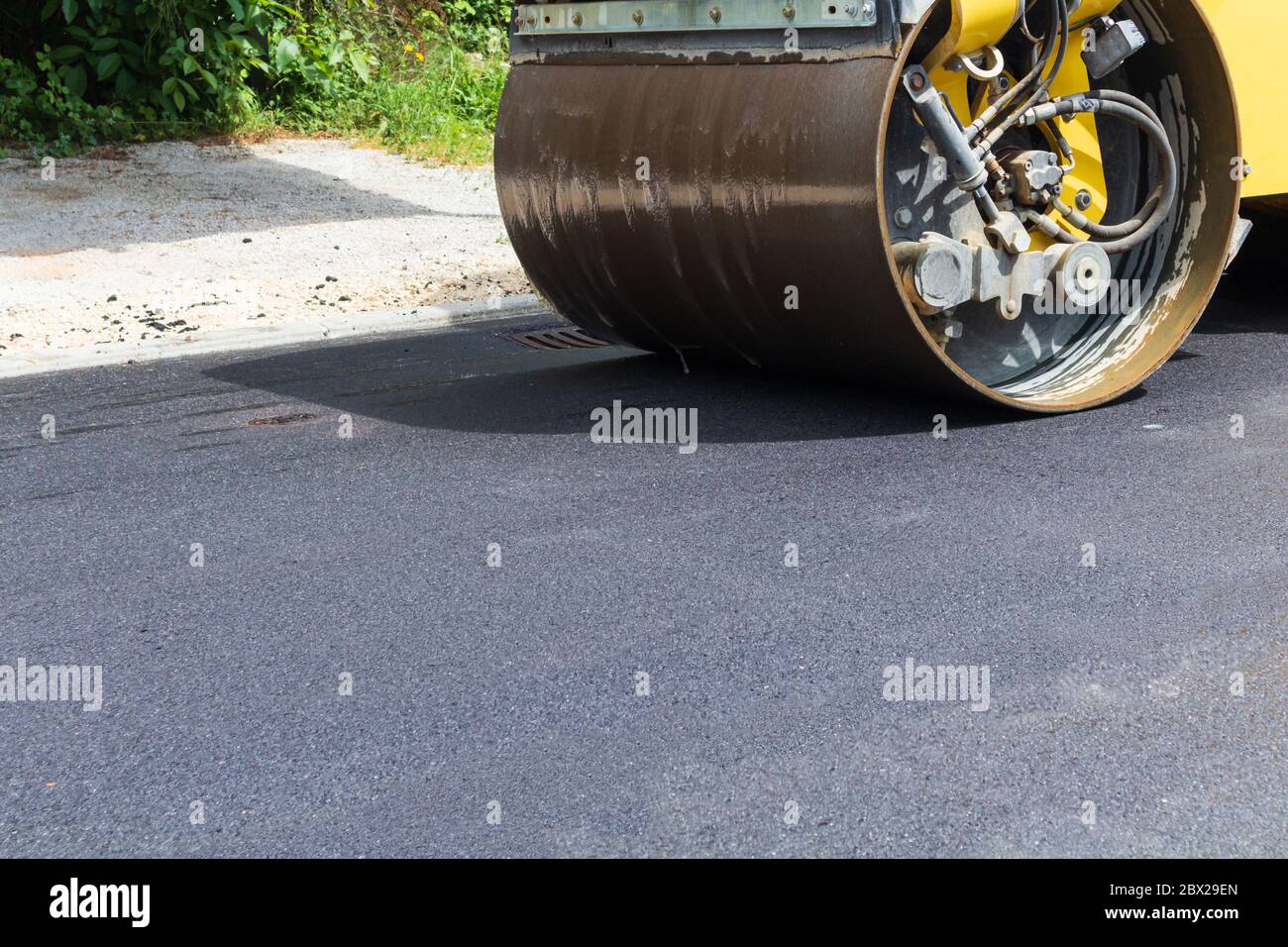 Asphalte noir frais sur la nouvelle route. La construction en cours. Banque D'Images