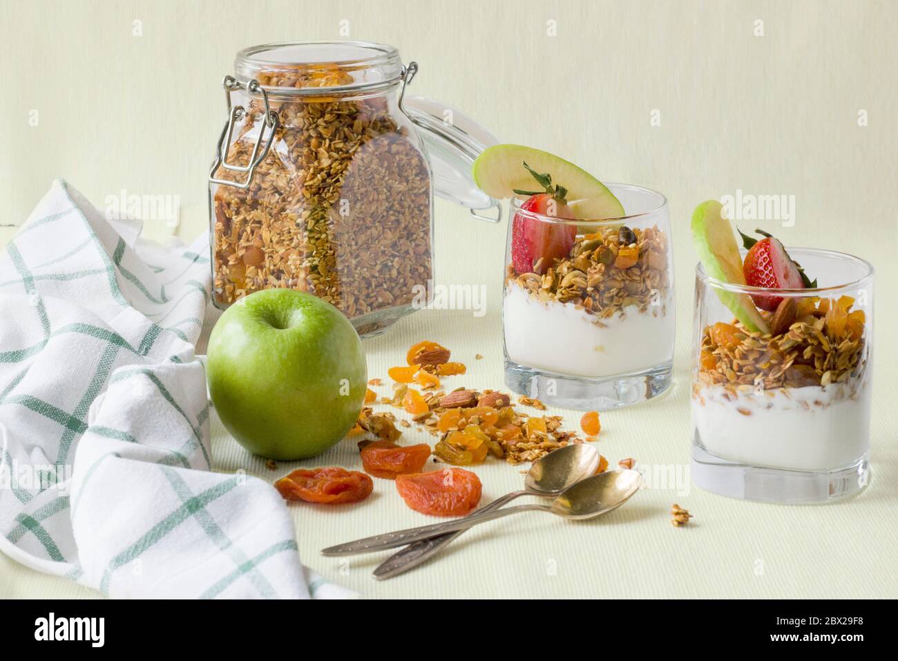 Deux portions dans des tasses transparentes de granola maison avec yaourt, noix et fruits secs Banque D'Images