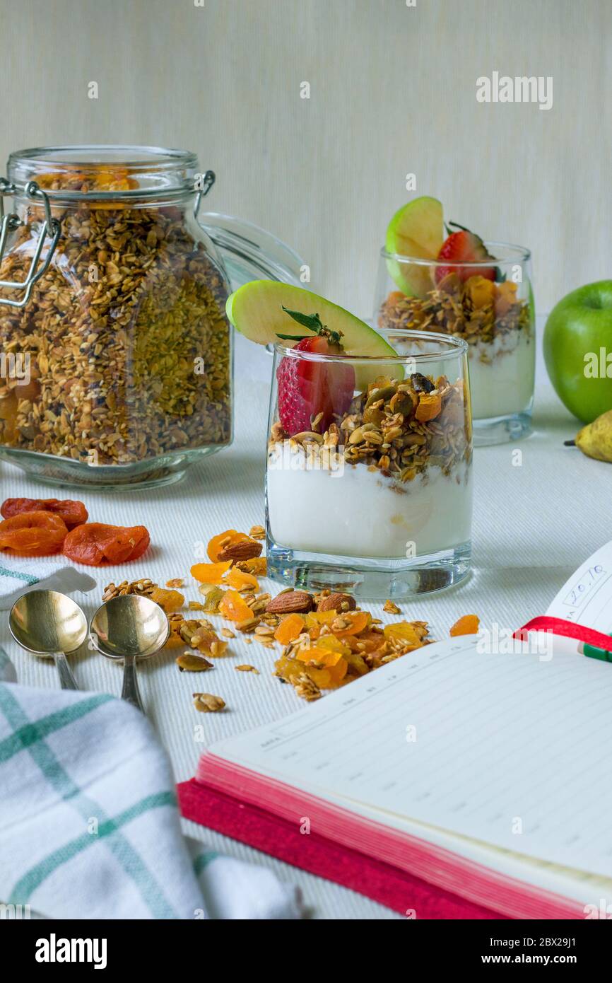 Deux portions dans des tasses transparentes de granola maison avec yaourt, noix et fruits secs Banque D'Images