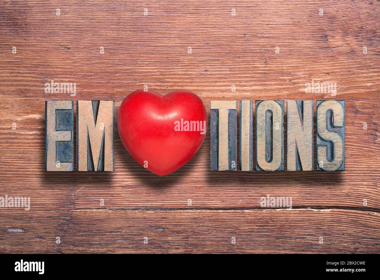mot d'émotions combiné sur une surface en bois verni vintage avec un symbole de coeur à l'intérieur Banque D'Images