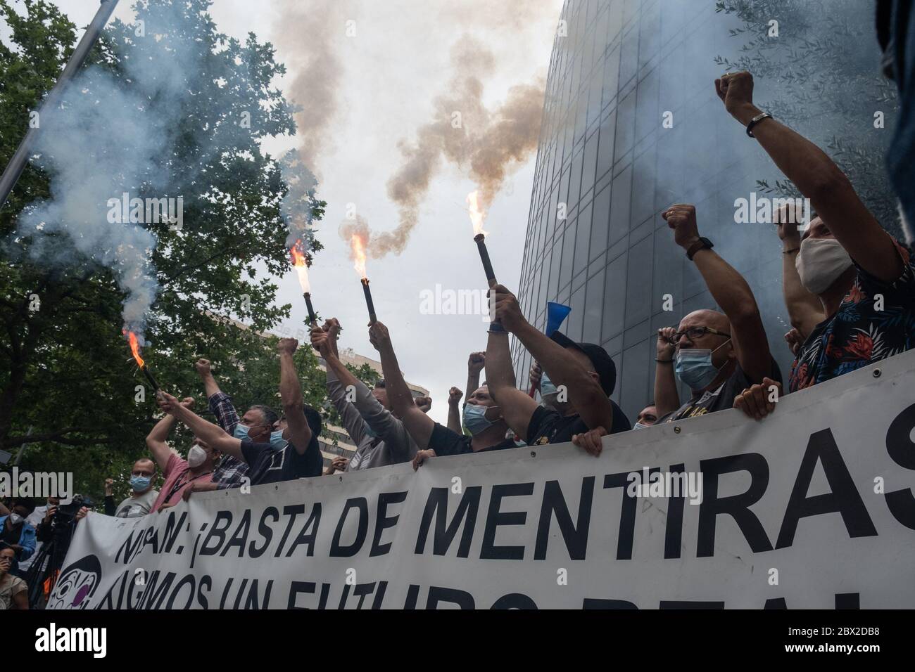 Des manifestants brûlent des torches pendant la manifestation.des travailleurs de Nissan ont manifesté au siège de l'Union européenne et au consulat japonais dans le cadre des mobilisations pour réclamer l'avenir de l'usine et empêcher sa fermeture. Le 28 mai, la marque a décidé de fermer ses usines en Espagne. Banque D'Images