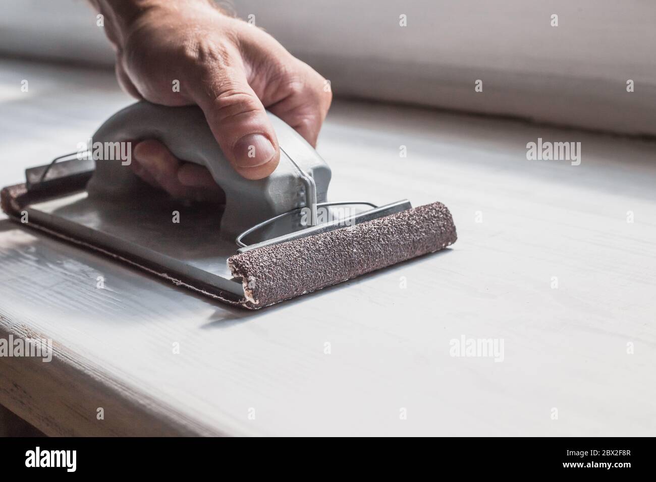 Préparation de la surface pour la peinture - meulage et retrait manuels de l'ancienne couche de peinture Banque D'Images