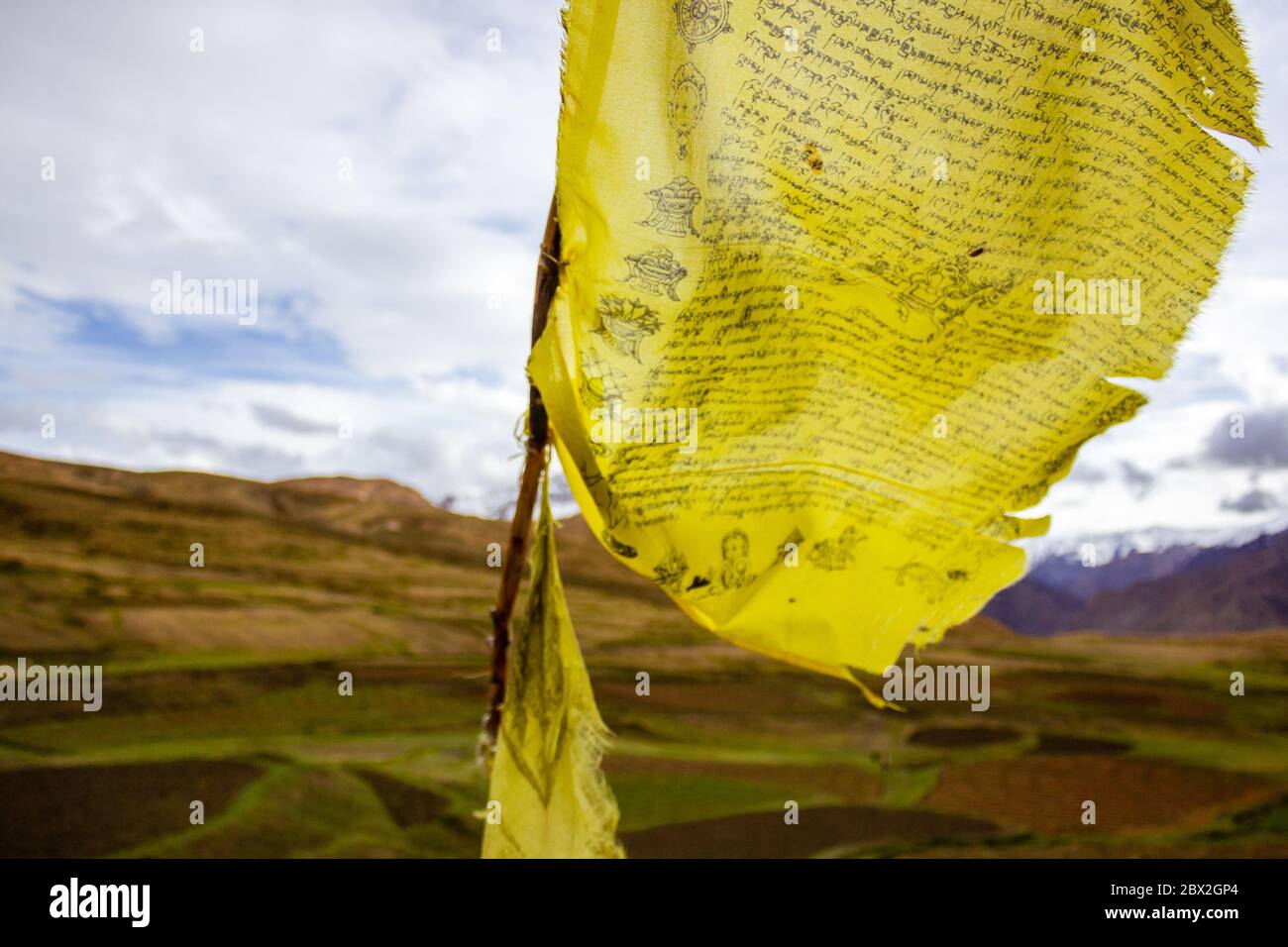 Un drapeau tibétain jaune de prière sur un col de montagne qui flotte dans le vent Banque D'Images Un drapeau tibétain jaune de prière sur un col de montagne qui flotte dans le vent Banque D'Images