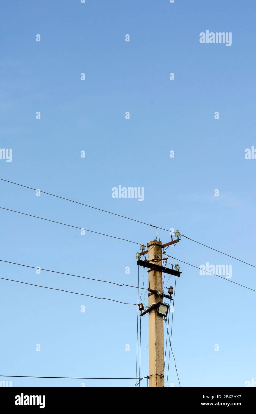 Montant avec fils contre le ciel. Poteau en béton avec beaucoup de fils et de spots LED. Industrie, électricité. Copier l'espace Banque D'Images