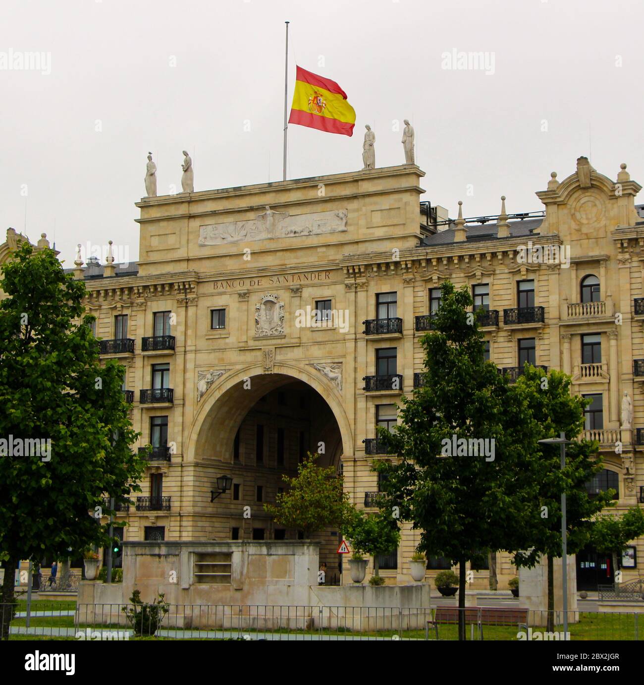 Bâtiment du siège de la banque Santander (Banco de Santander) avec un gros plan du drapeau national espagnol à mi-mât pendant 10 jours de deuil Banque D'Images