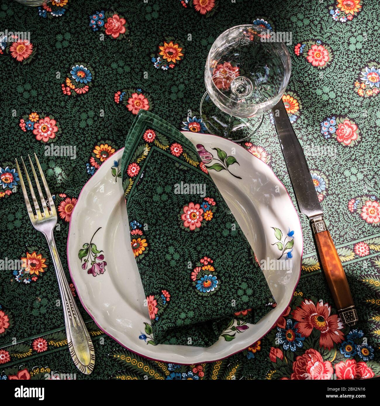 Une nappe et des couverts simples mais élégants. Verres en cristal au soleil. Tout est prêt pour le déjeuner dans le jardin.France. Banque D'Images