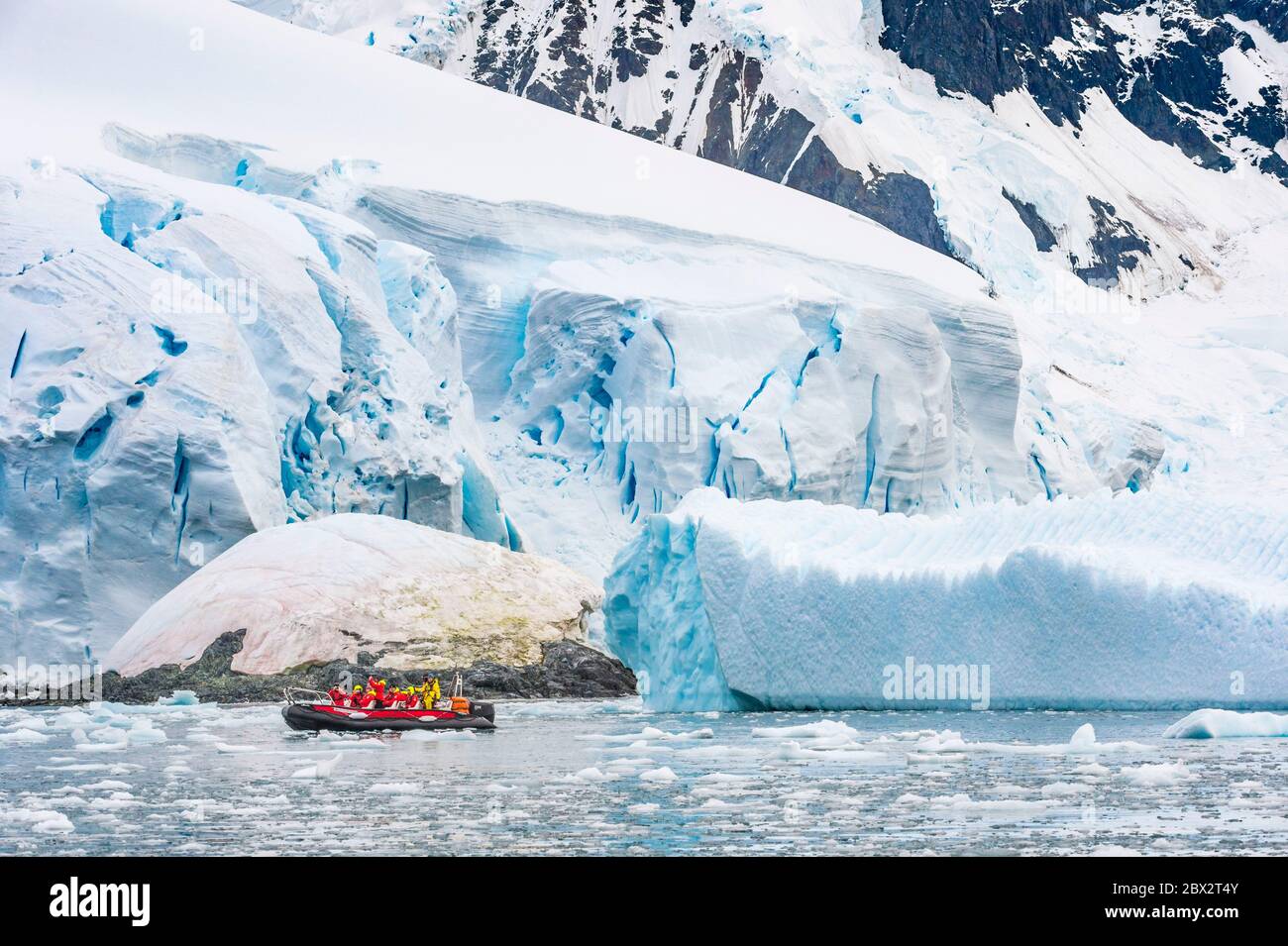 Antarctique, Océan Austral, Péninsule Antarctique, Graham Land, chenal Lemaire, exploration du chenal entre icebergs à la recherche de la vie marine dans un petit bateau semi-rigide, un glacier en arrière-plan Banque D'Images