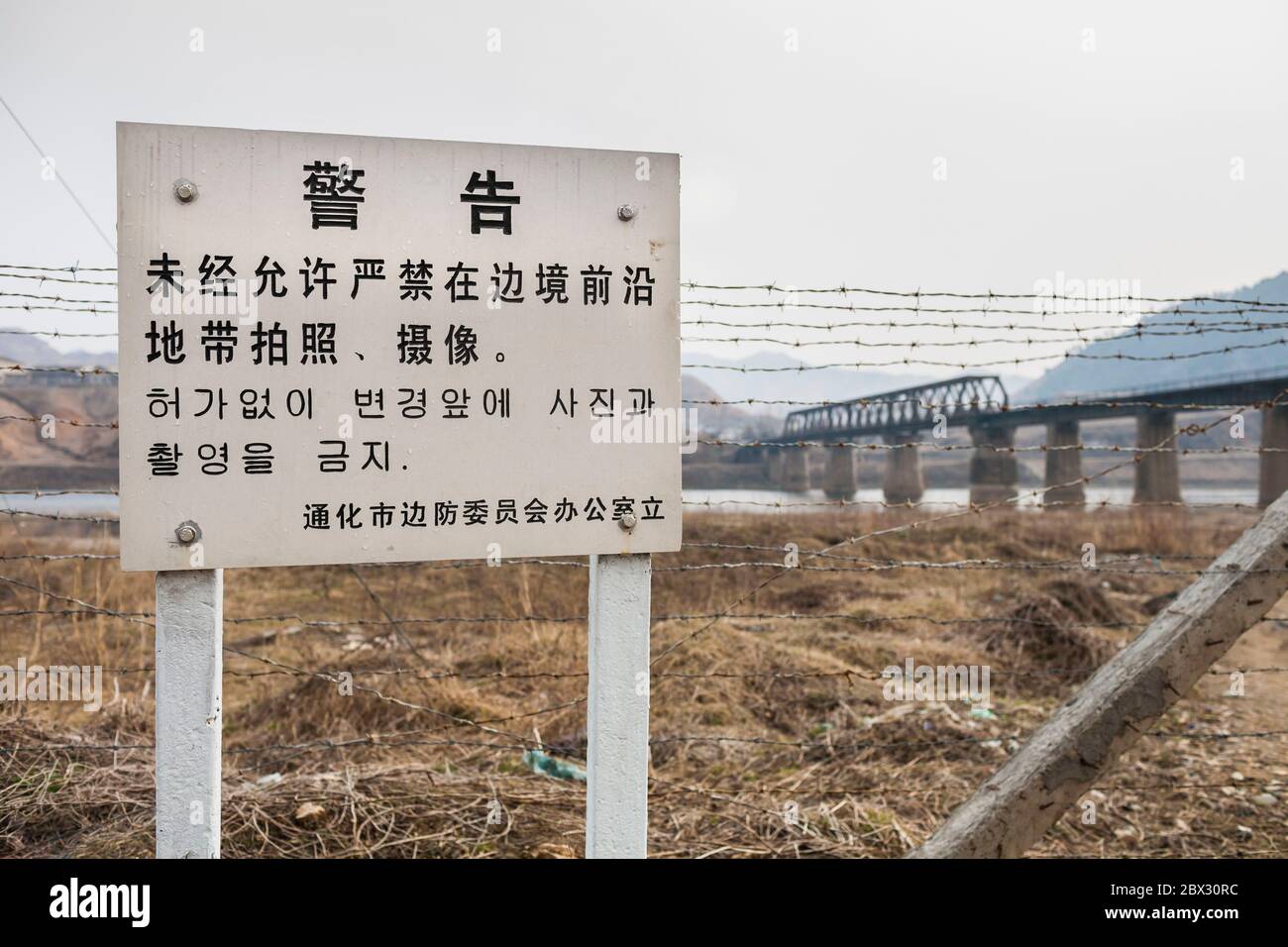 Chine, province de Jilin, ville de Ji'an, préfecture autonome de Corée Yanbienne, signez en chinois et en coréen l'avertissement qu'il est interdit de prendre des photos du pont ferroviaire frontalier de la rivière Yalu Banque D'Images