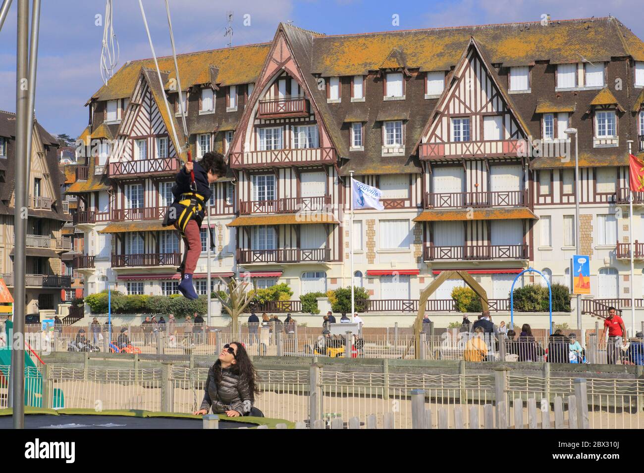 France, Calvados, pays d'Auge, Trouville sur Mer, club de plage avec trampoline à l'élastique et en arrière-plan les planches Promenade Savignac et un bâtiment en bord de mer du début du XXe siècle Banque D'Images