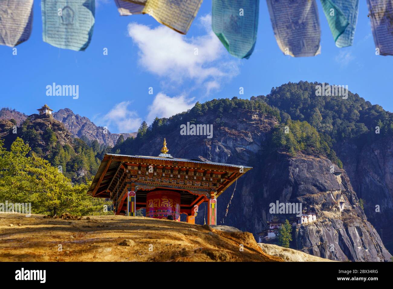 Grande roue de prière et drapeaux de prière en randonnée jusqu’au Nest de Tiger ou à Taktshang Lhakhang au Bhoutan. Banque D'Images