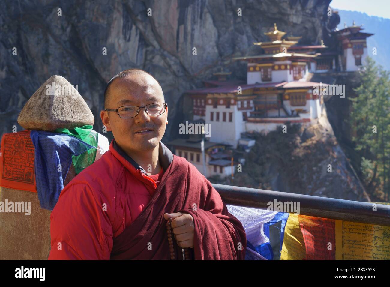 Monk, originaire d’Inde, avec des perles de prière, fait des pauses pour le portrait lors du pèlerinage au Tigre’s Nest au Bhoutan. Banque D'Images