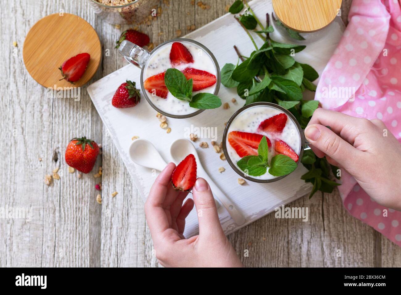 Concept de saine alimentation petit déjeuner. Parfait aux fraises avec yaourt, graines de chia, granola maison et baies fraîches sur un plan de travail en pierre. Vue de dessus Banque D'Images