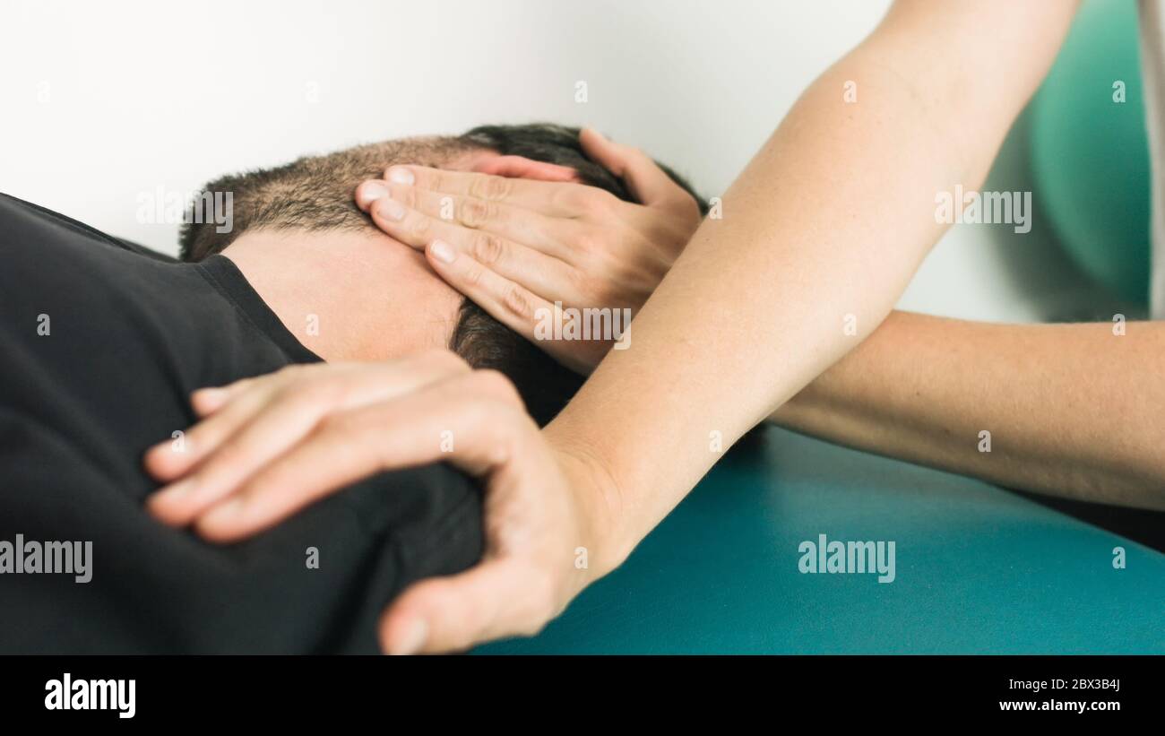 Physiothérapeute effectuant des massages et des étirements avec une personne sur une table de thérapie. Banque D'Images
