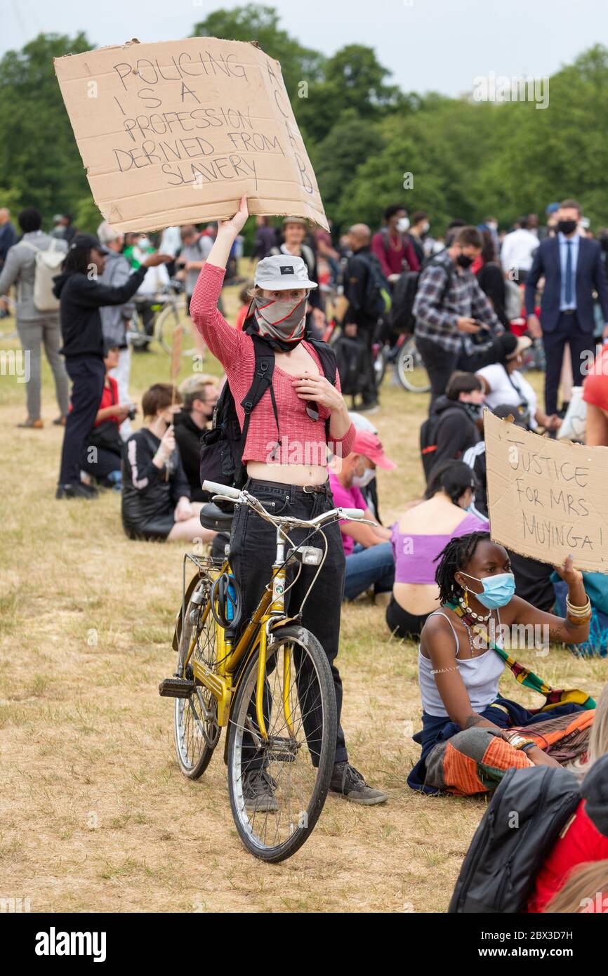 Une femme debout à côté de son vélo et tenant un panneau au Black Lives Matters proteste à Hyde Park, Londres, 3 juin 2020 Banque D'Images
