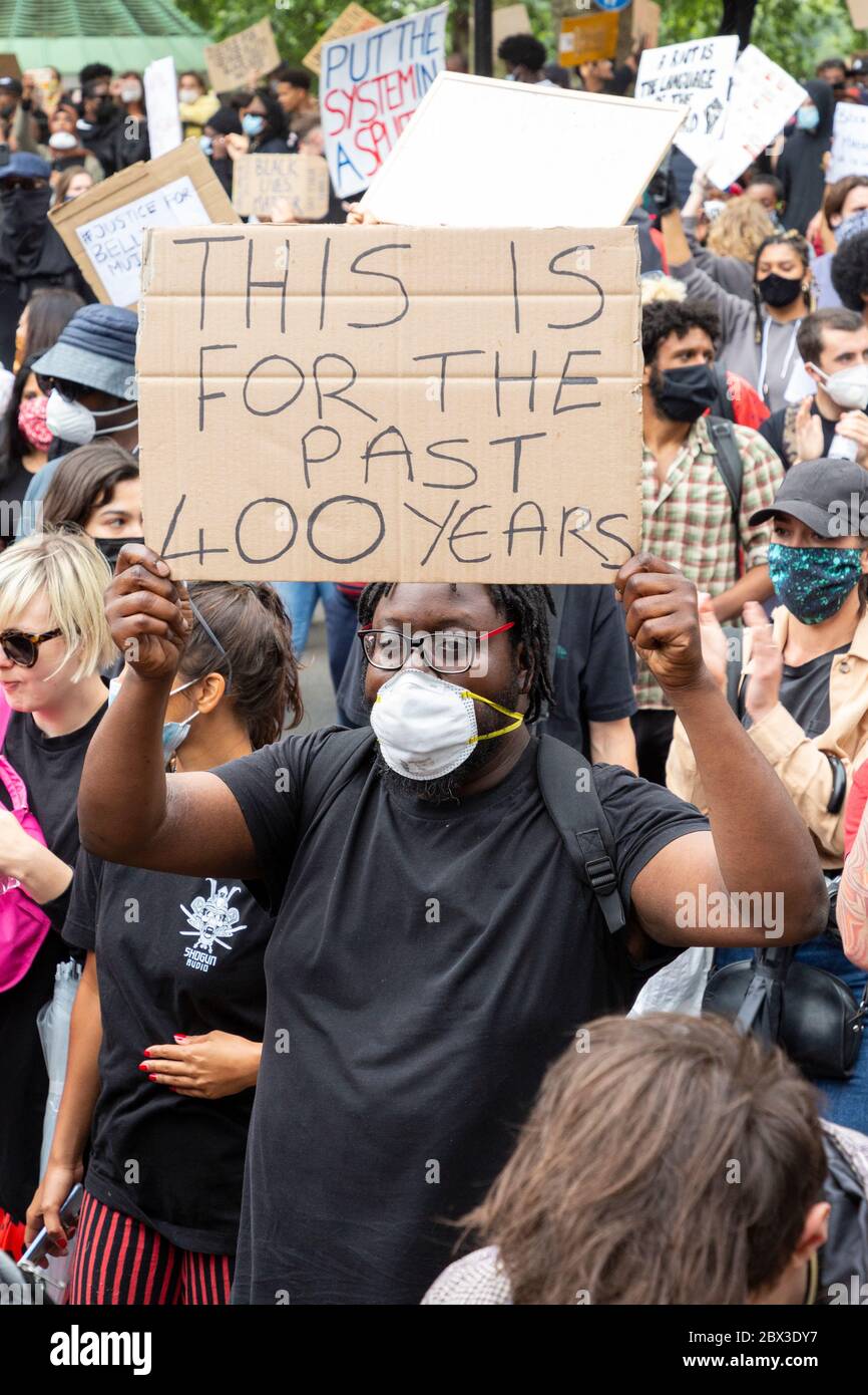 Un homme marchant et tenant un panneau à la Black Lives Matters proteste à Londres, le 3 juin 2020 Banque D'Images