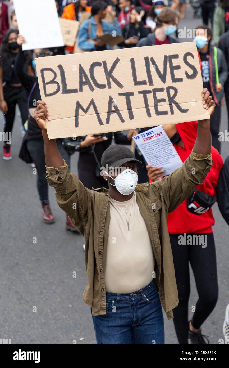 Un homme portant un masque et tenant un panneau pendant la marche à Black Lives Matters proteste à Londres, le 3 juin 2020 Banque D'Images