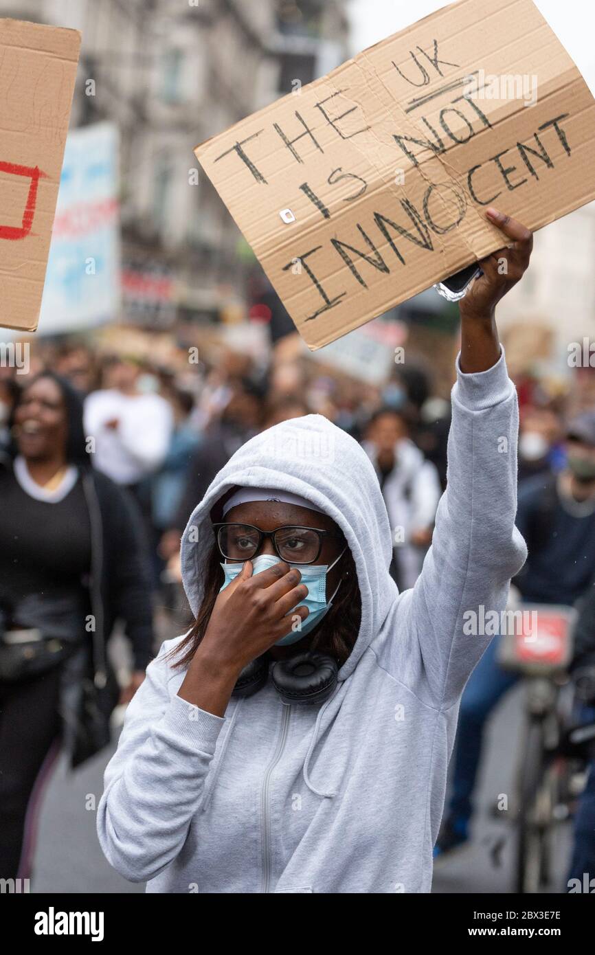 Une fille tenant un panneau et ajustant son masque facial pendant la marche à la Black Lives Matters manifestation à Londres, 3 juin 2020 Banque D'Images