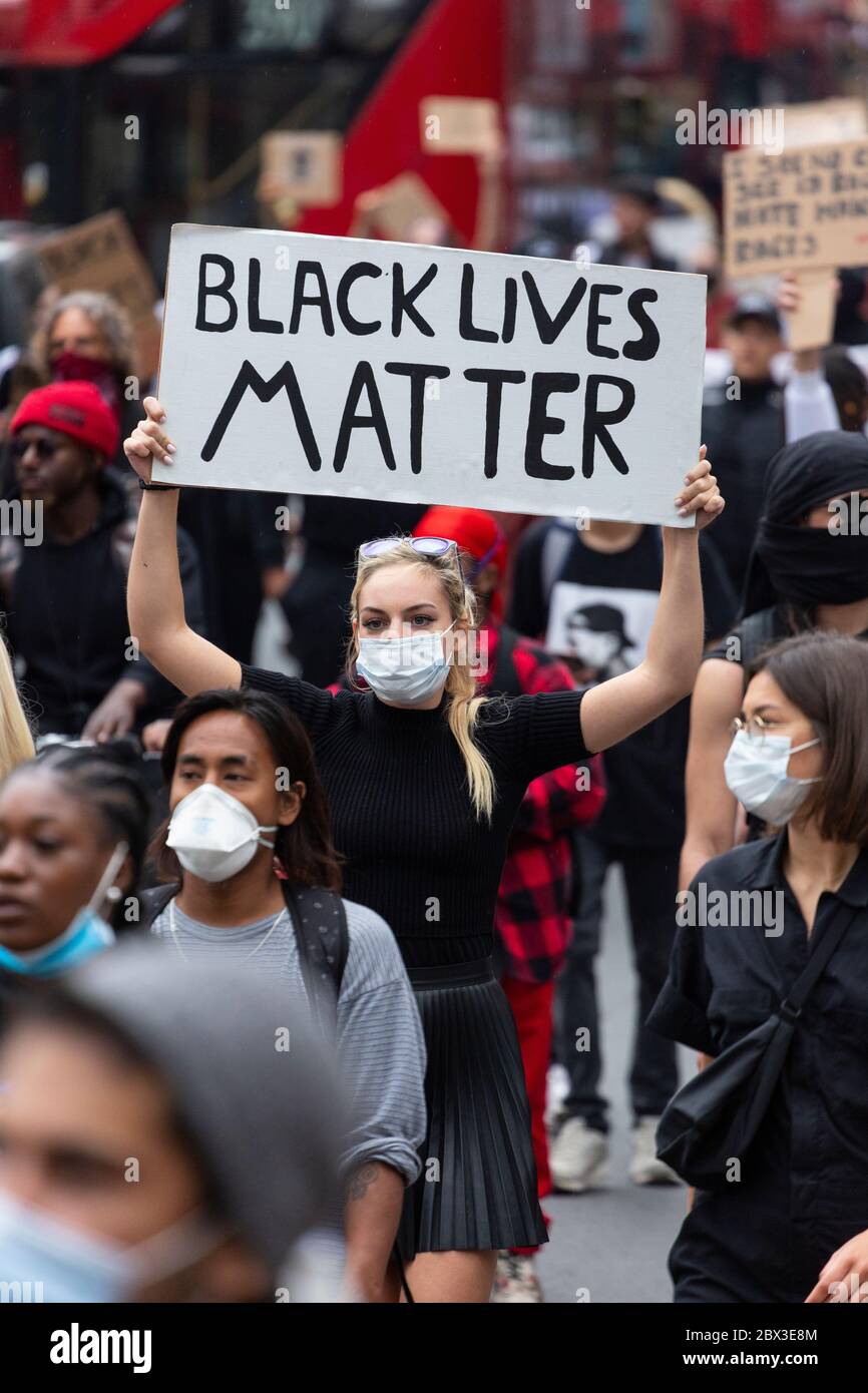 Une jeune fille blanche marchant et tenant un panneau à Black Lives Matters proteste à Londres, le 3 juin 2020 Banque D'Images