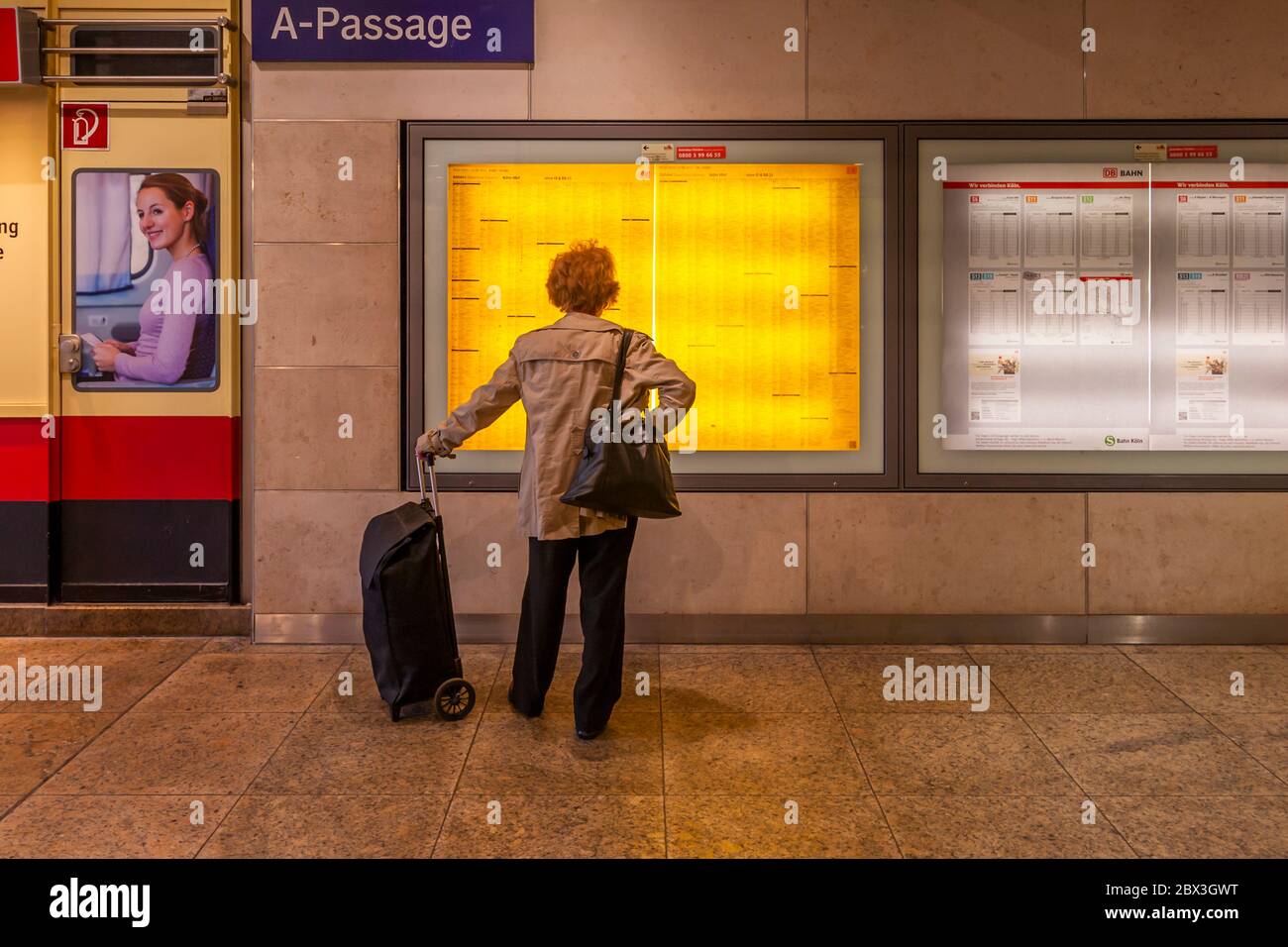 Un voyageur étudie l'horaire affiché à la gare centrale de Cologne, en Allemagne Banque D'Images