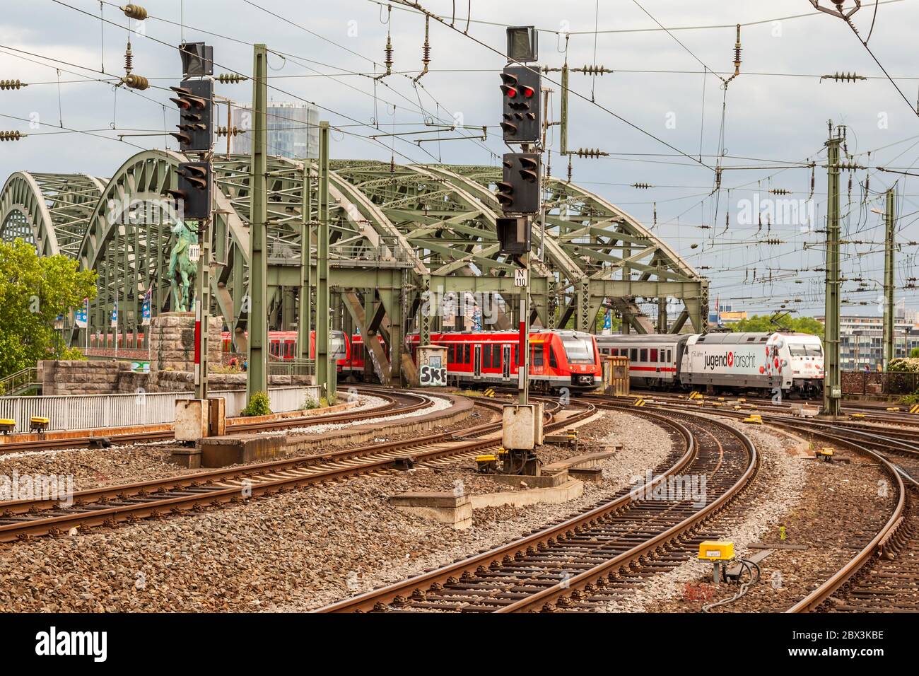 Trois trains traversent le pont Hohenzollern sur le Rhin à la gare centrale de Cologne, en Allemagne Banque D'Images