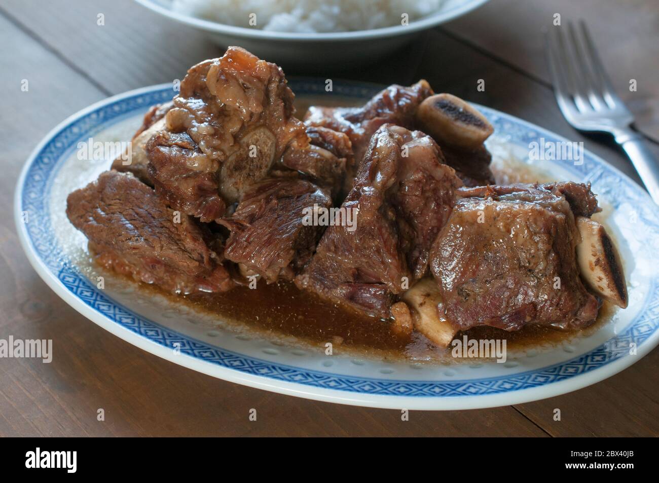 Gros plan, macro photographie de côtes de bœuf en sauce aux huîtres avec une assiette de riz au fond, concept alimentaire asiatique Banque D'Images