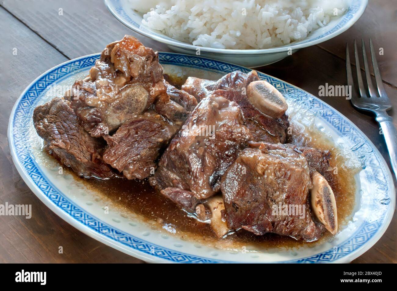 Gros plan, macro photographie de côtes de bœuf en sauce aux huîtres avec une assiette de riz au fond, concept alimentaire asiatique Banque D'Images