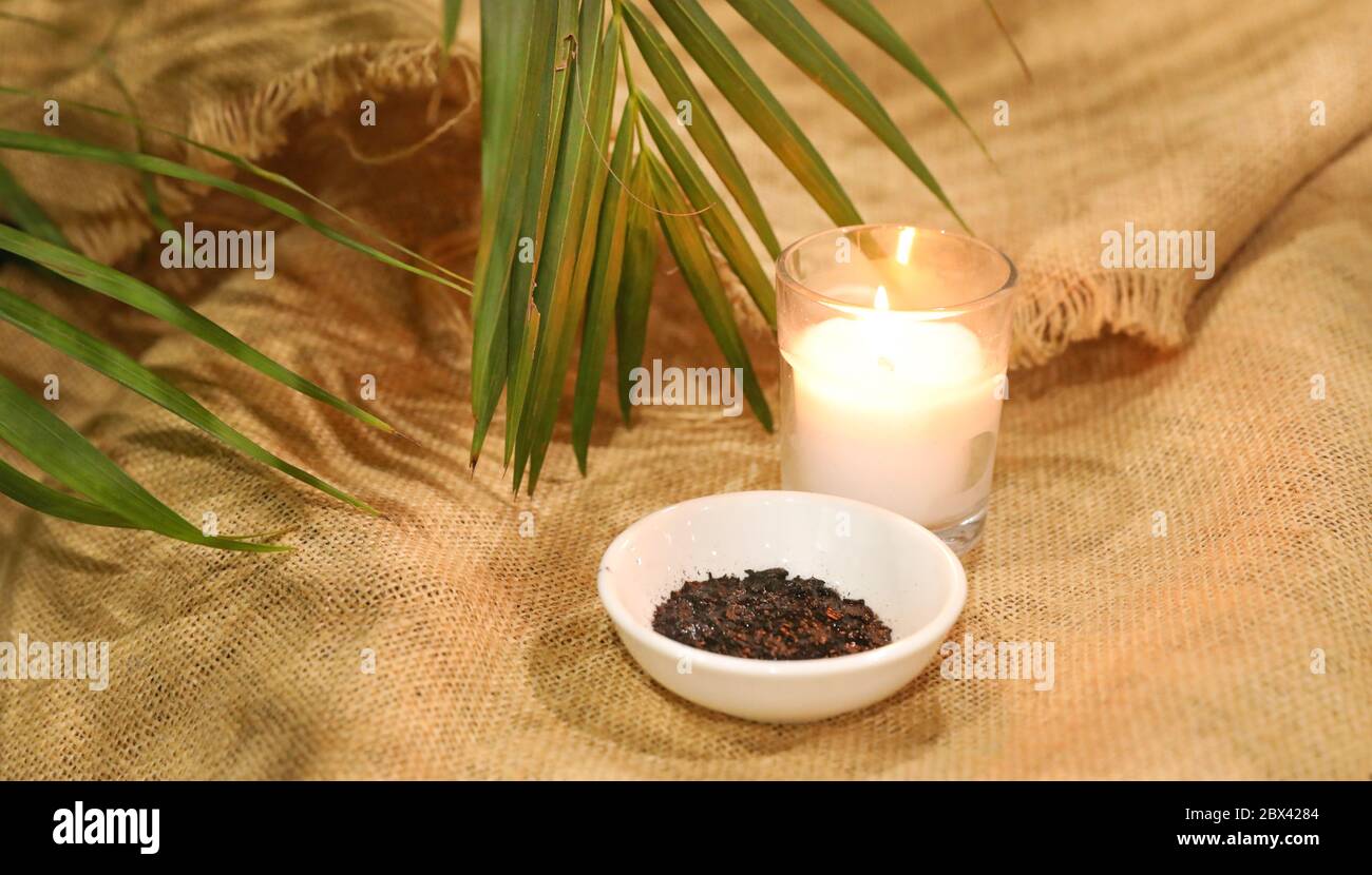 Mercredi de cendres début de la saison de prêté. Petit bol de cendres brûlées des années précédentes Palm dimanche service d'église. Bougie et paume vivante lea Banque D'Images