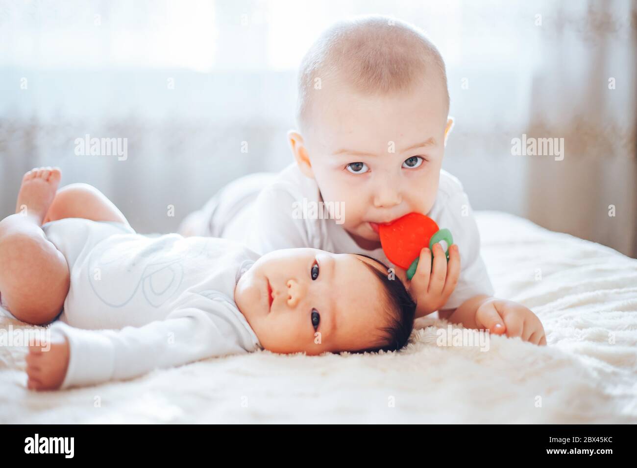 Bébé Enfant couché sur le ventre avec dentition couche portés par... Banque D'Images