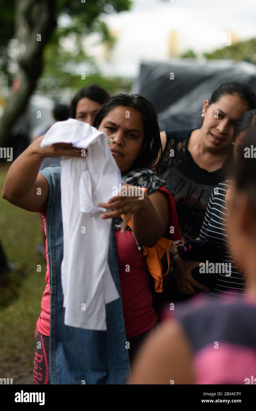 Un groupe de femmes vénézuéliennes bloquées se réunit pour distribuer des vêtements privés dans le camp de fortune créé dans le contexte de la pandémie de Covid-19, où elles ont été conçues Banque D'Images