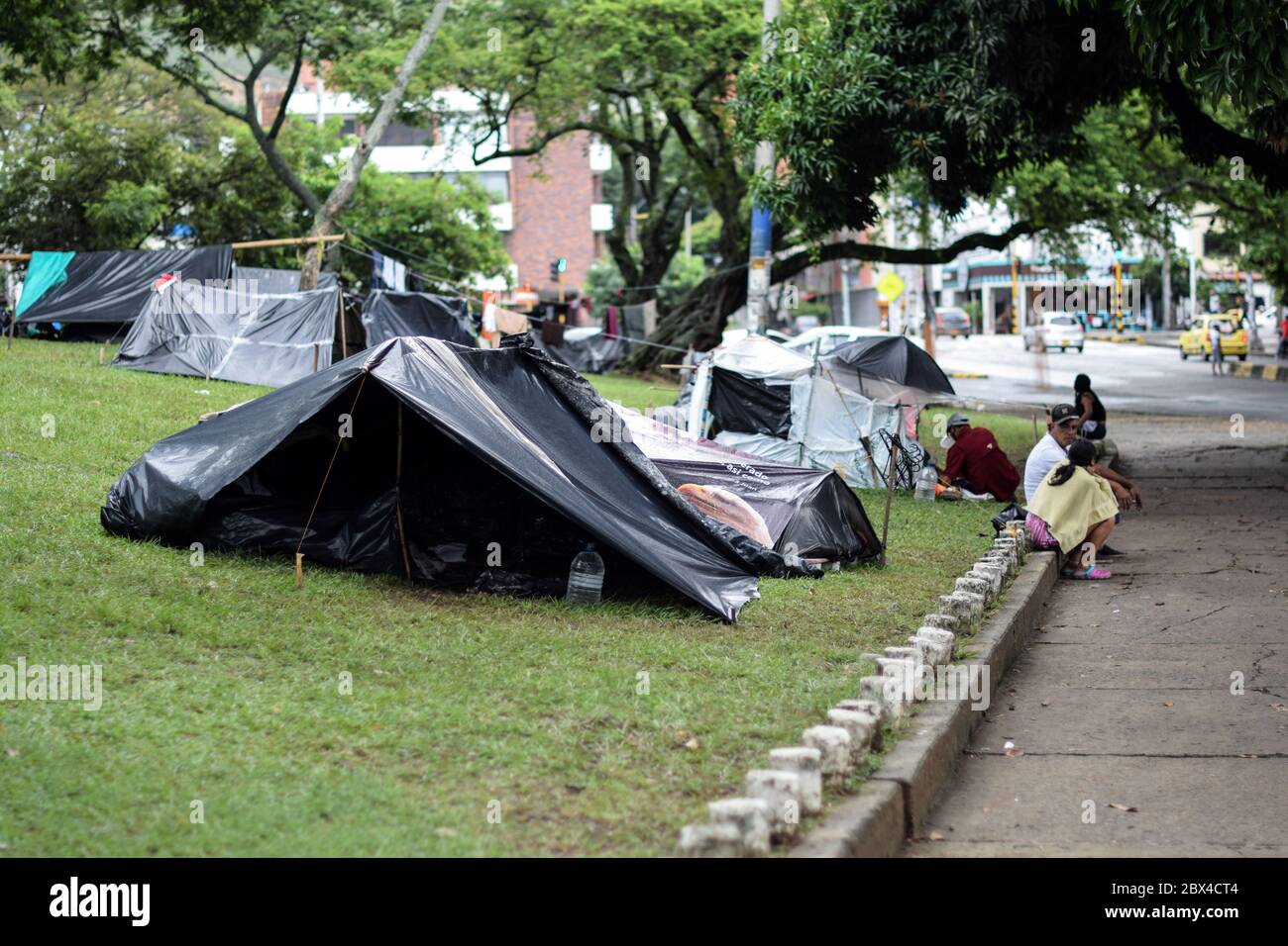 Les Vénézuéliens bloqués construisent un camp de fortune dans un parc couvert d'arbres au milieu de la pandémie de Covid-19, en attendant l'occasion de retourner dans leur pays, Cali, Banque D'Images