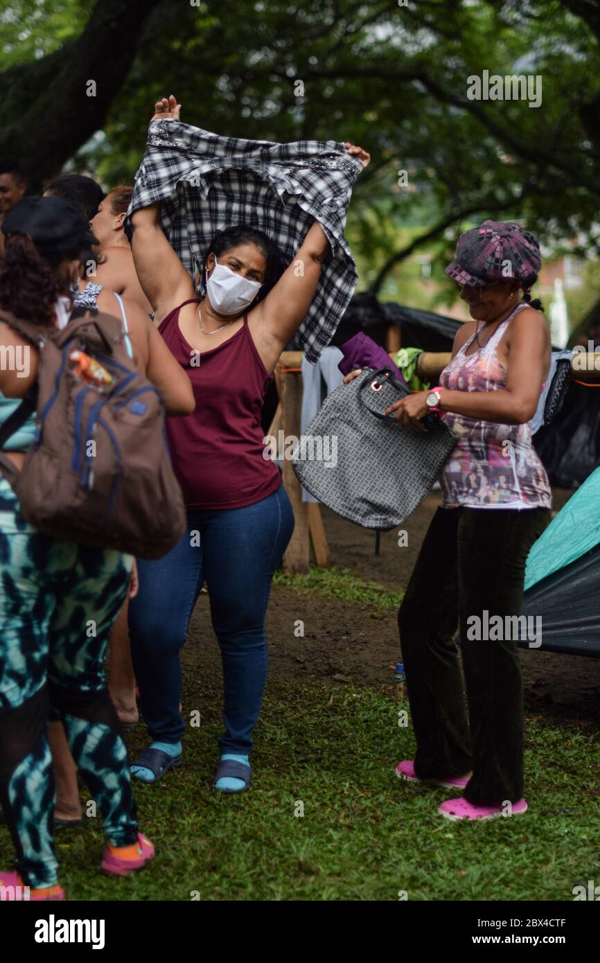 Un groupe de femmes vénézuéliennes bloquées se réunit pour distribuer des vêtements privés dans le camp de fortune créé dans le contexte de la pandémie de Covid-19, où elles ont été conçues Banque D'Images