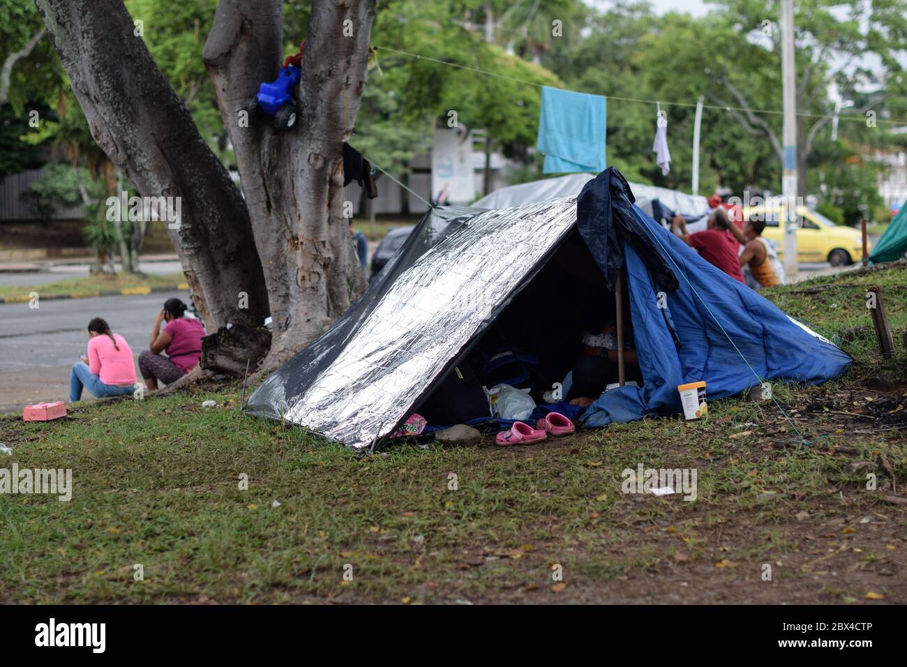 Les Vénézuéliens bloqués construisent un camp de fortune dans un parc couvert d'arbres au milieu de la pandémie de Covid-19, en attendant l'occasion de retourner dans leur pays, Cali, Banque D'Images