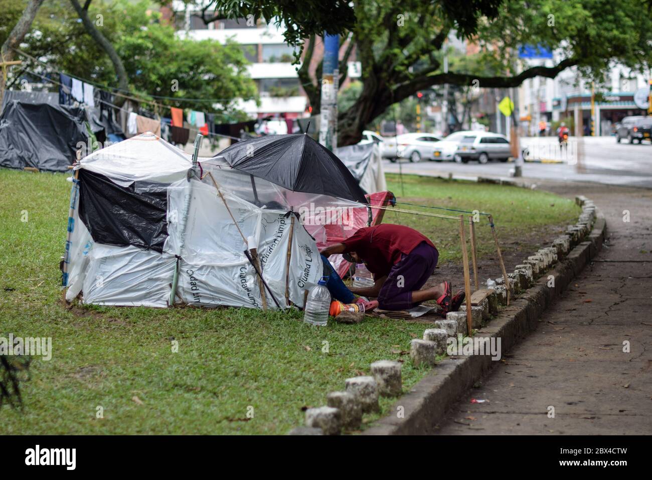 Les Vénézuéliens bloqués construisent un camp de fortune dans un parc couvert d'arbres au milieu de la pandémie de Covid-19, en attendant l'occasion de retourner dans leur pays, Cali, Banque D'Images