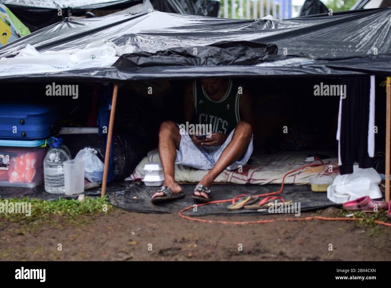 Les Vénézuéliens bloqués construisent un camp de fortune dans un parc couvert d'arbres au milieu de la pandémie de Covid-19, en attendant l'occasion de retourner dans leur pays, Cali, Banque D'Images