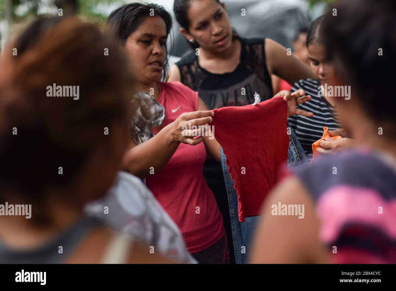 Un groupe de femmes vénézuéliennes bloquées se réunit pour distribuer des vêtements privés dans le camp de fortune créé dans le contexte de la pandémie de Covid-19, où elles ont été conçues Banque D'Images