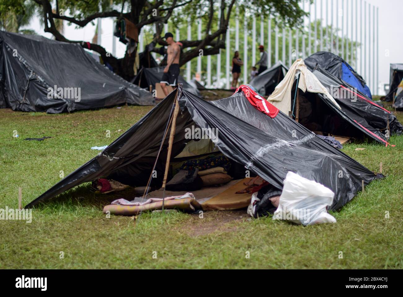 Les Vénézuéliens bloqués construisent un camp de fortune dans un parc couvert d'arbres au milieu de la pandémie de Covid-19, en attendant l'occasion de retourner dans leur pays, Cali, Banque D'Images