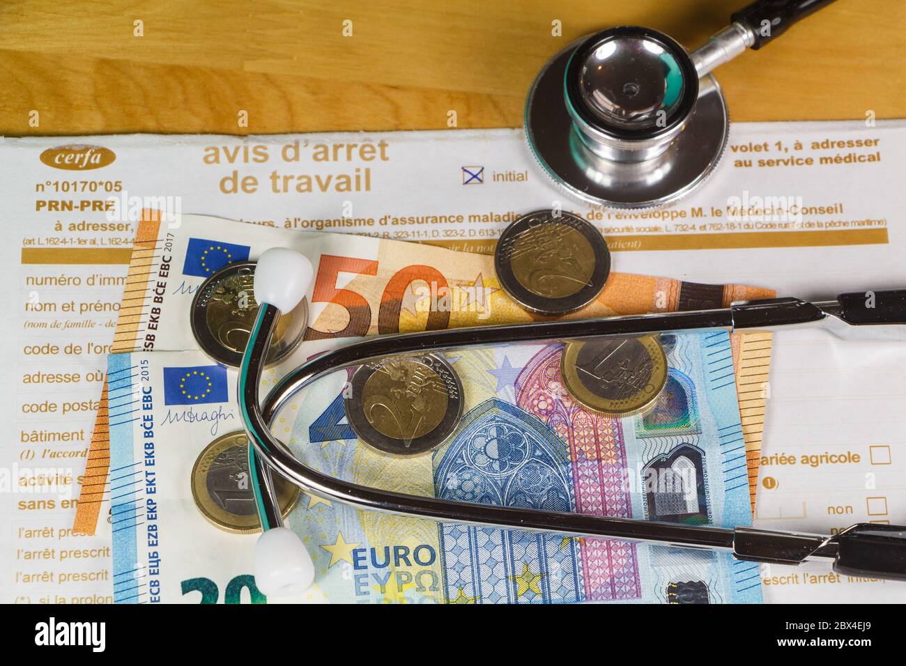 Notice d'arrêt du travail médical français, stéthoscope noir, pièces en euros et billets Banque D'Images
