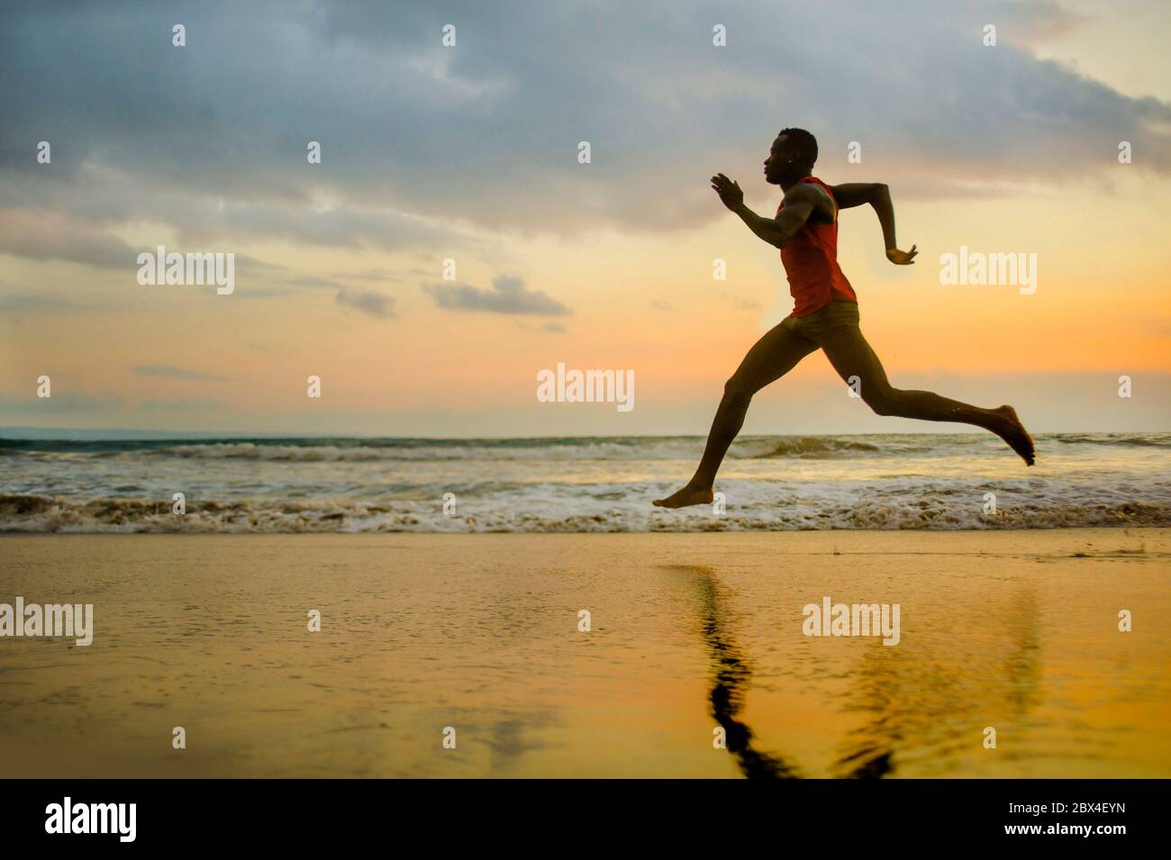 Silhouette de jeune coupe attrayante athlétique et noir fort Africain américain courir au coucher du soleil entraînement de plage dur et de sprint sur l'eau de mer dedans Banque D'Images