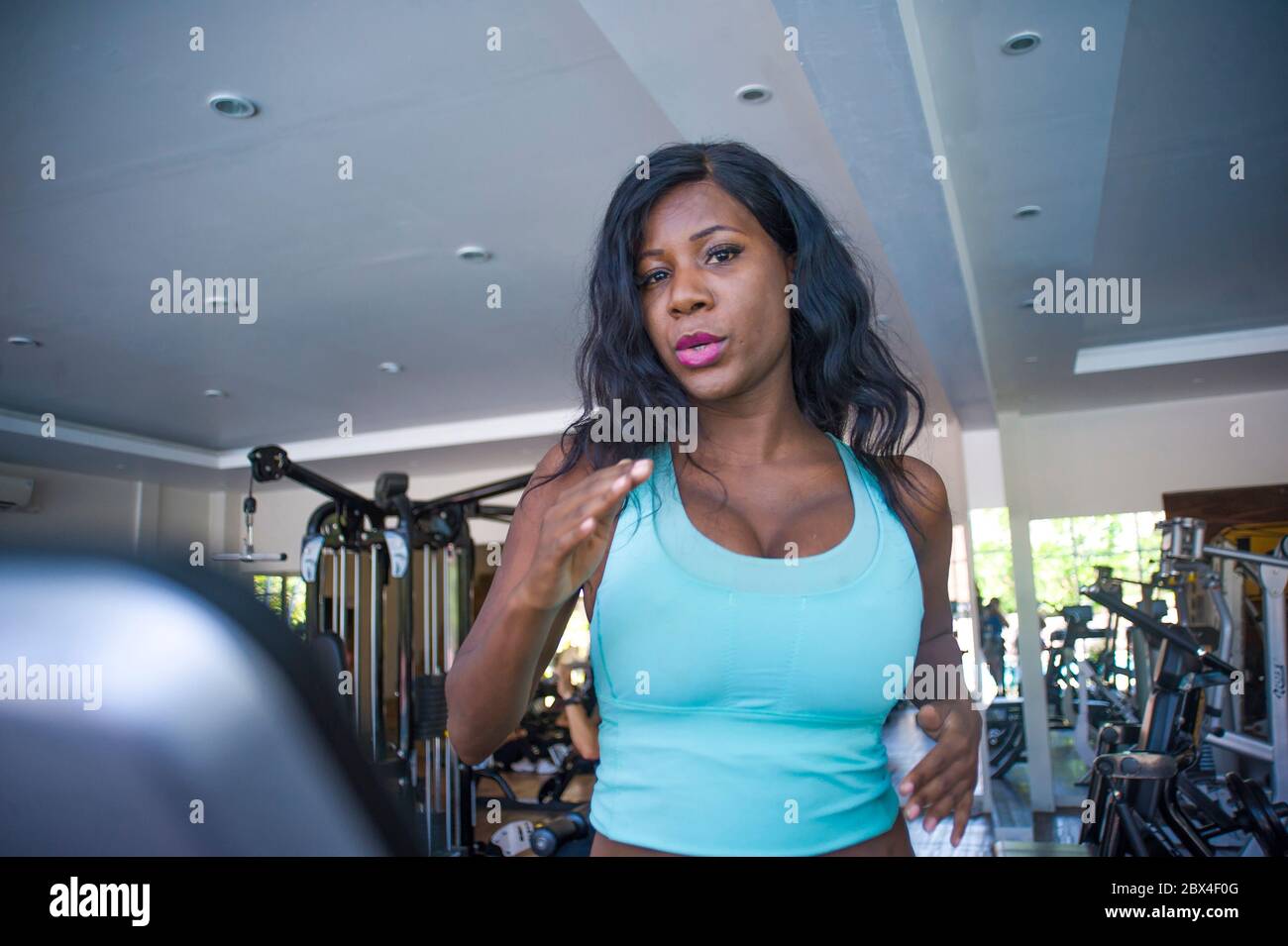 Intérieur gym portrait de jeune attrayant et beau noir afro-américain sportif femme entraînement tapis roulant entraînement à l'entraînement à la forme physique club dans le corps Banque D'Images