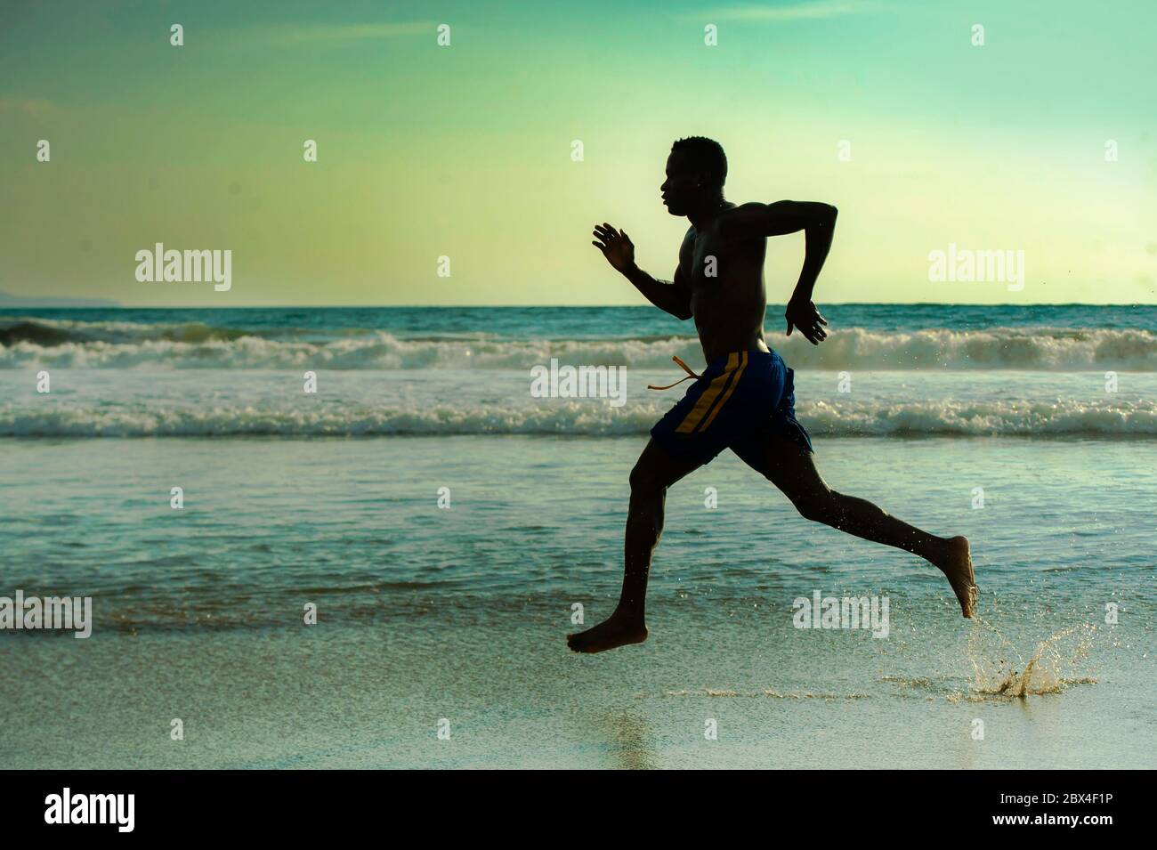 Silhouette de jeune coupe attrayante athlétique et noir fort Africain américain courir au coucher du soleil entraînement de plage dur et de sprint sur l'eau de mer dedans Banque D'Images